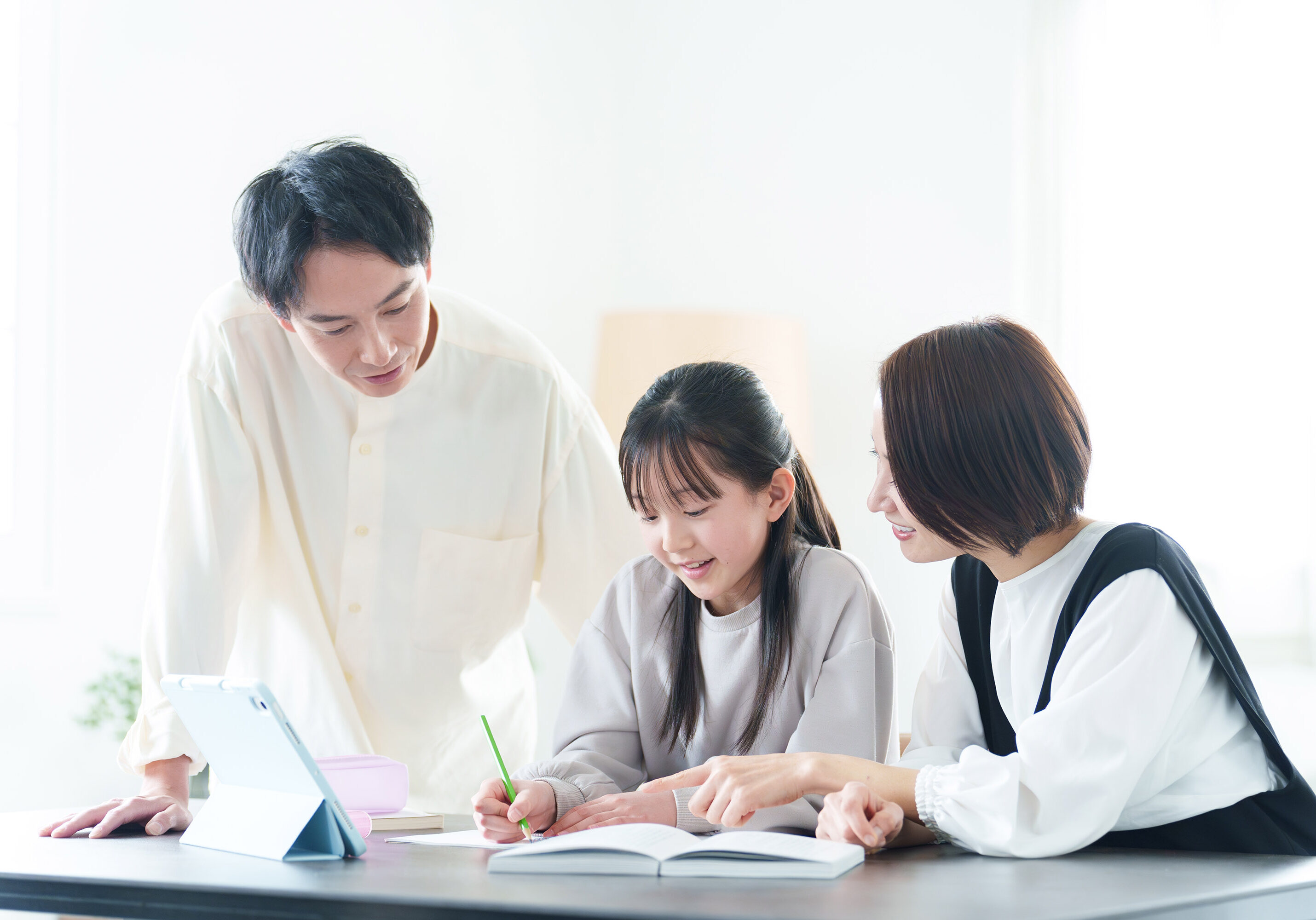 parents teaching their daughter to study in the living room